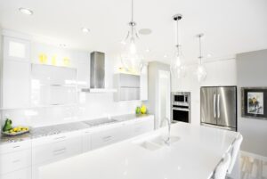 A homeowner inspects a granite kitchen countertop sample near a sunlit window with swatches and cabinet colors visible.
