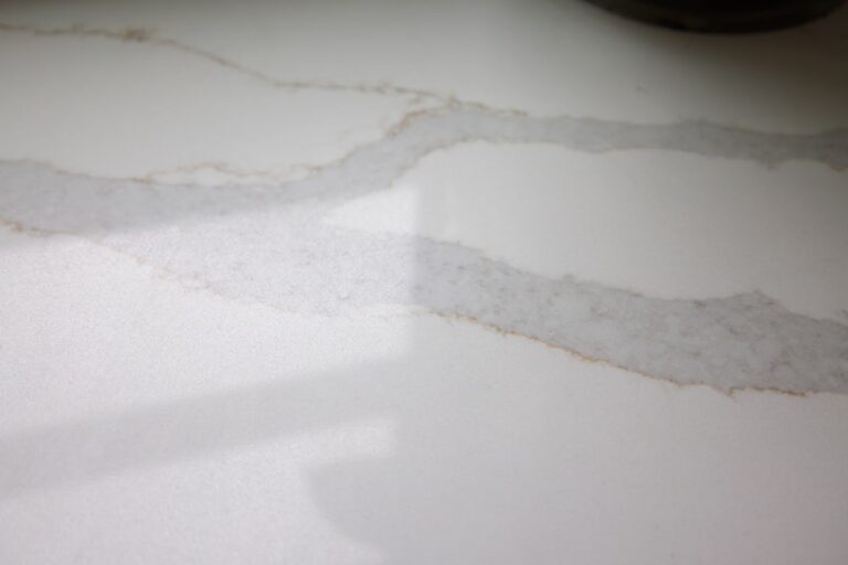 A person wiping a natural stone kitchen countertop with a soft cloth.