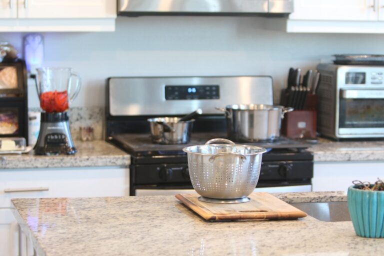 A person wearing gloves gently wiping a granite kitchen countertop with a damp cloth.