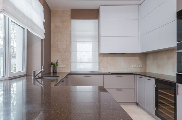 A homeowner measuring a large stone countertop slab in a bright residential kitchen.