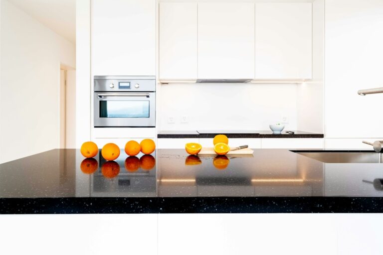Close-up of polished stone countertop edges showing eased, rounded, and decorative profiles beside kitchen cabinets